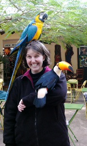 woman with large bird on her arm and head laughing
