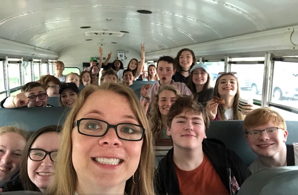 Emily takes a selfie in front her students when they're on a school bus ready to go to a master class.