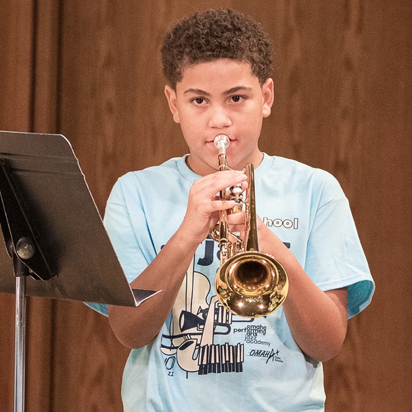 Student reading music and playing a trumpet